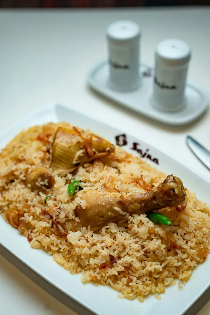A white plate topped with rice and meat
